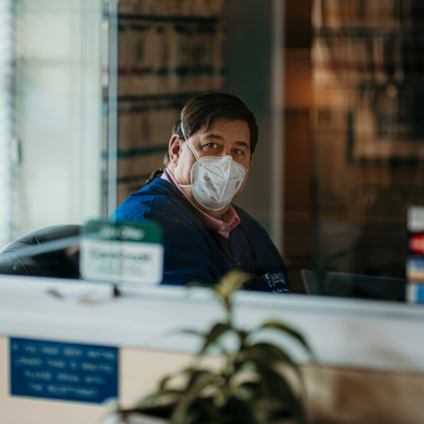 Paul at Front Desk with PPE mask on